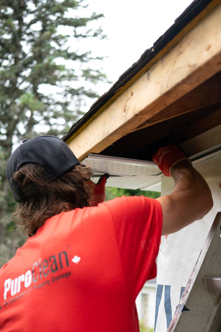 Contractor installing aluminum K-style seamless gutters on a residential home