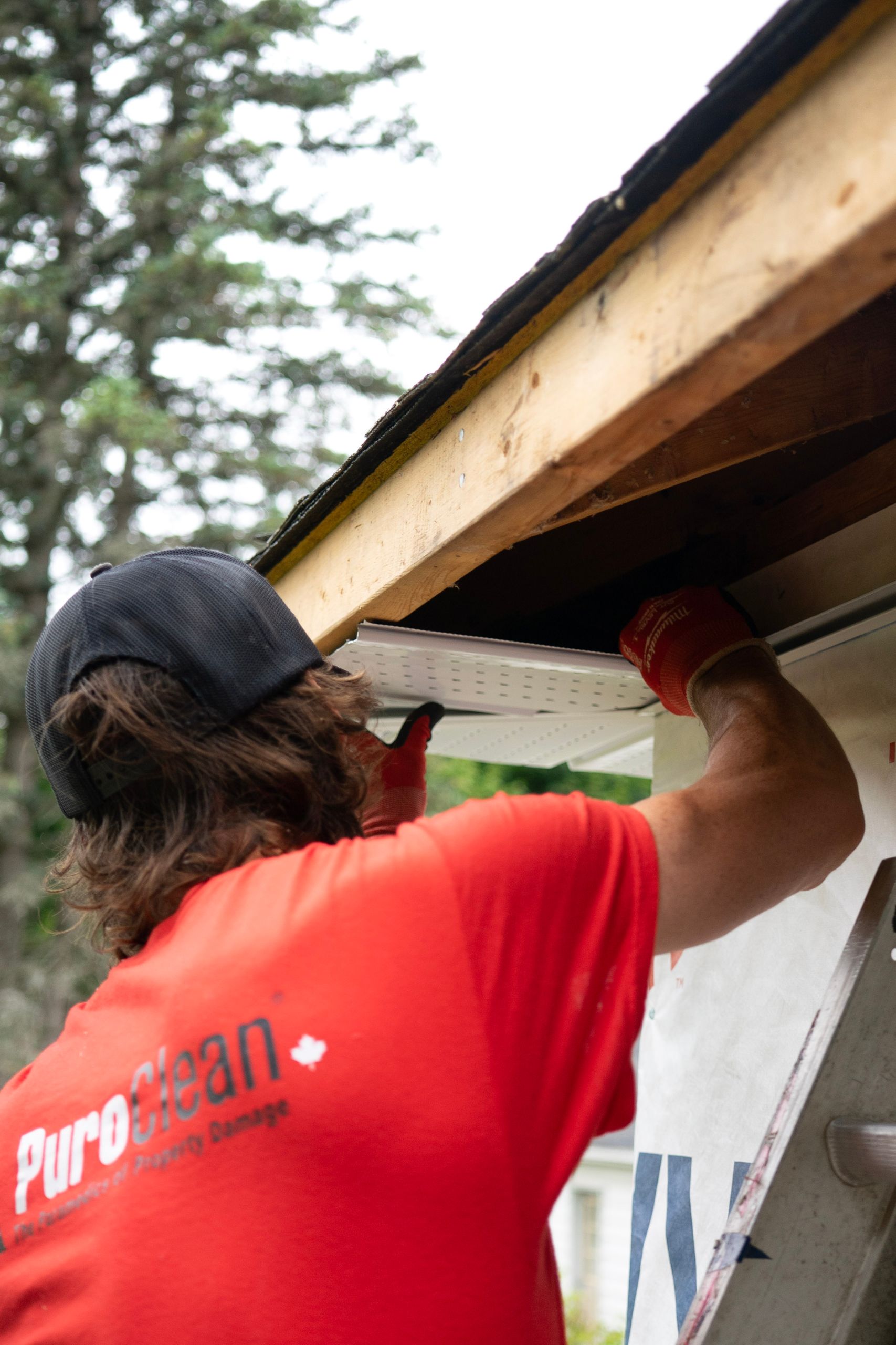 Contractor installing aluminum K-style seamless gutters on a residential home