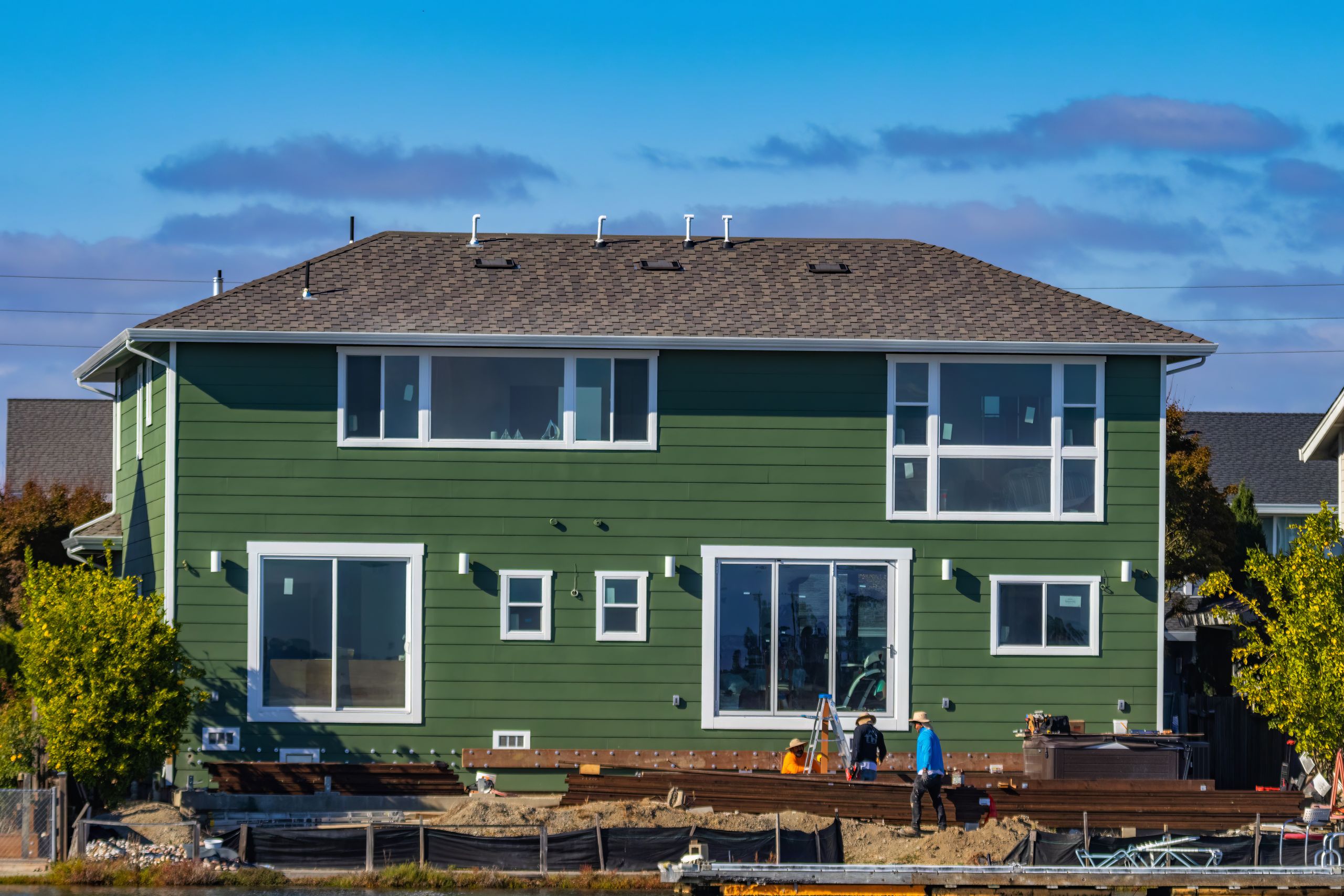 Contractor installing vinyl siding panels on a house exterior