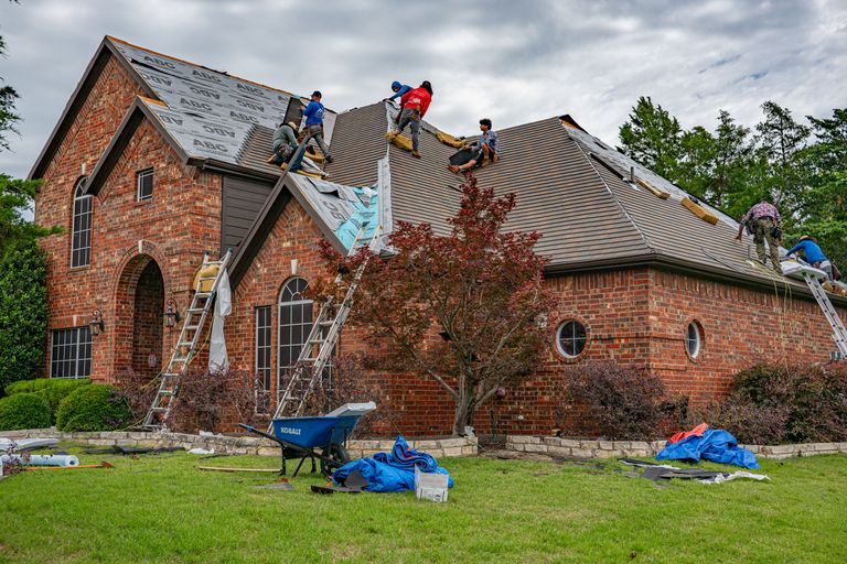 Roofer installing asphalt shingles on a residential roof